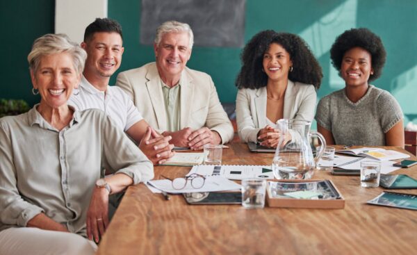 Group of happy white collar workers sitting around a table