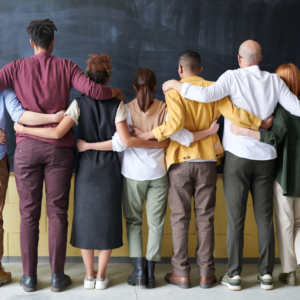 group of people with arms around each other facing away from the camera